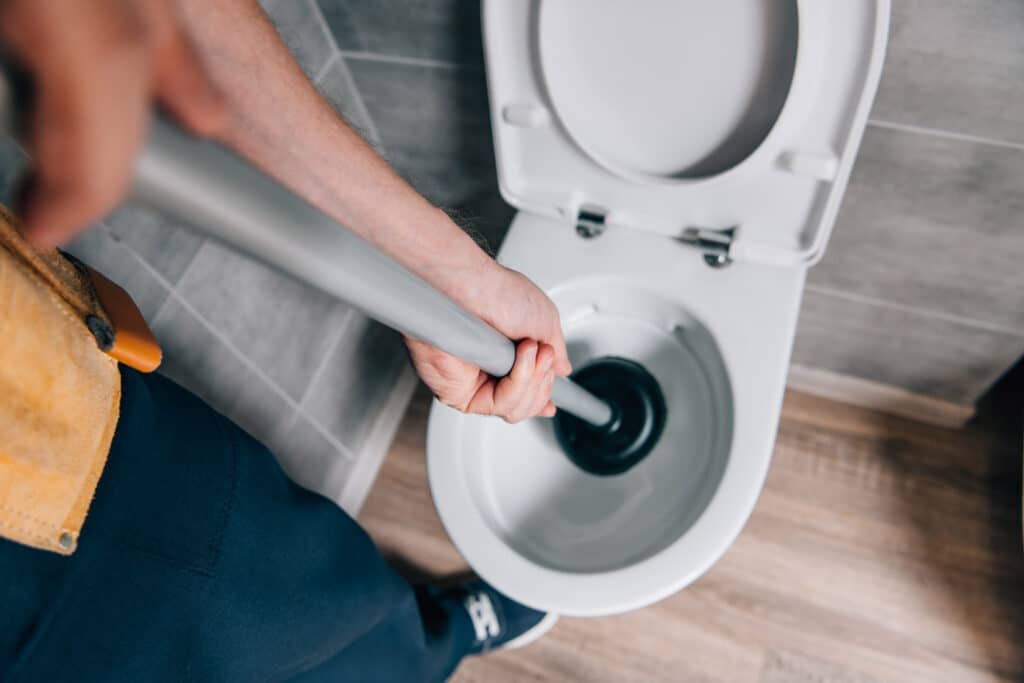 Homme debouche toilette