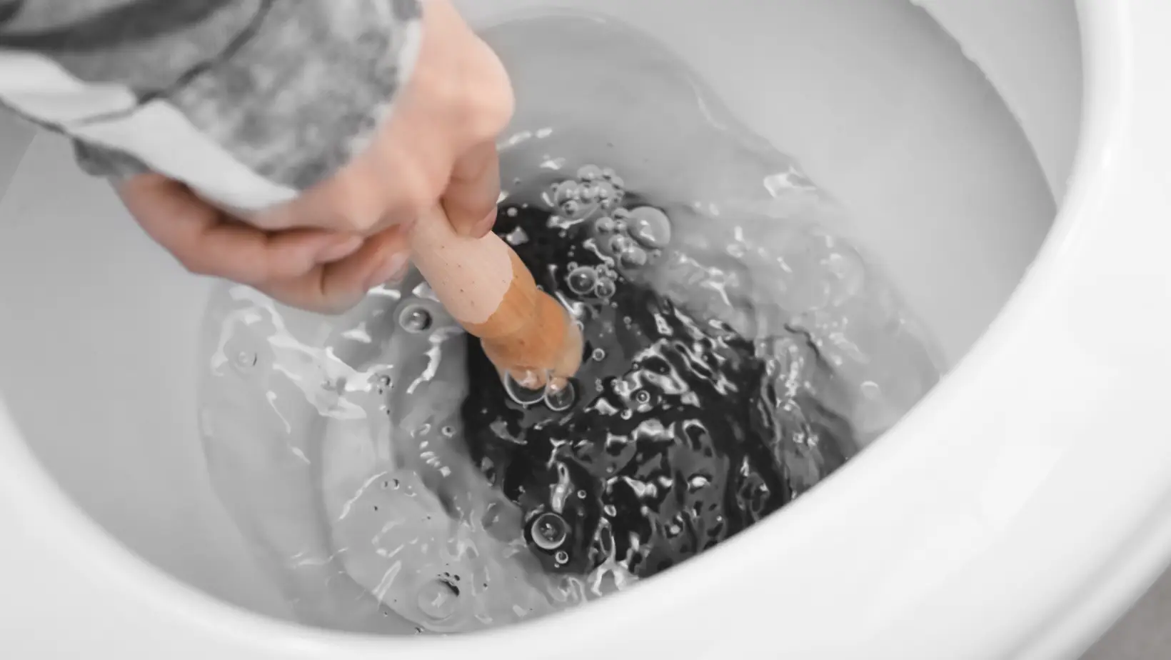 homme en train de déboucher des toilettes